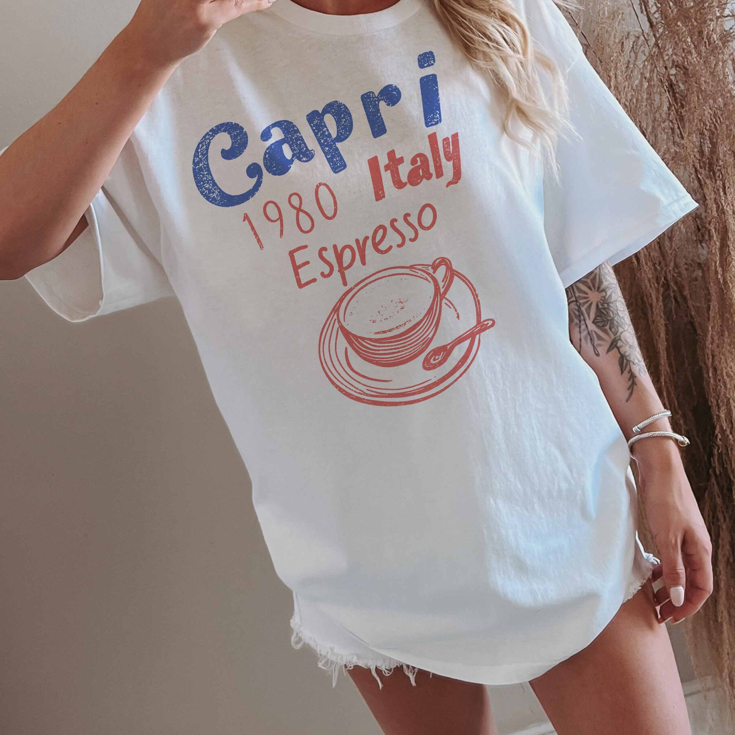 Frau trägt ein Oversized Grafik T-Shirt Capri in weiß mit italienischem Espresso-Design.