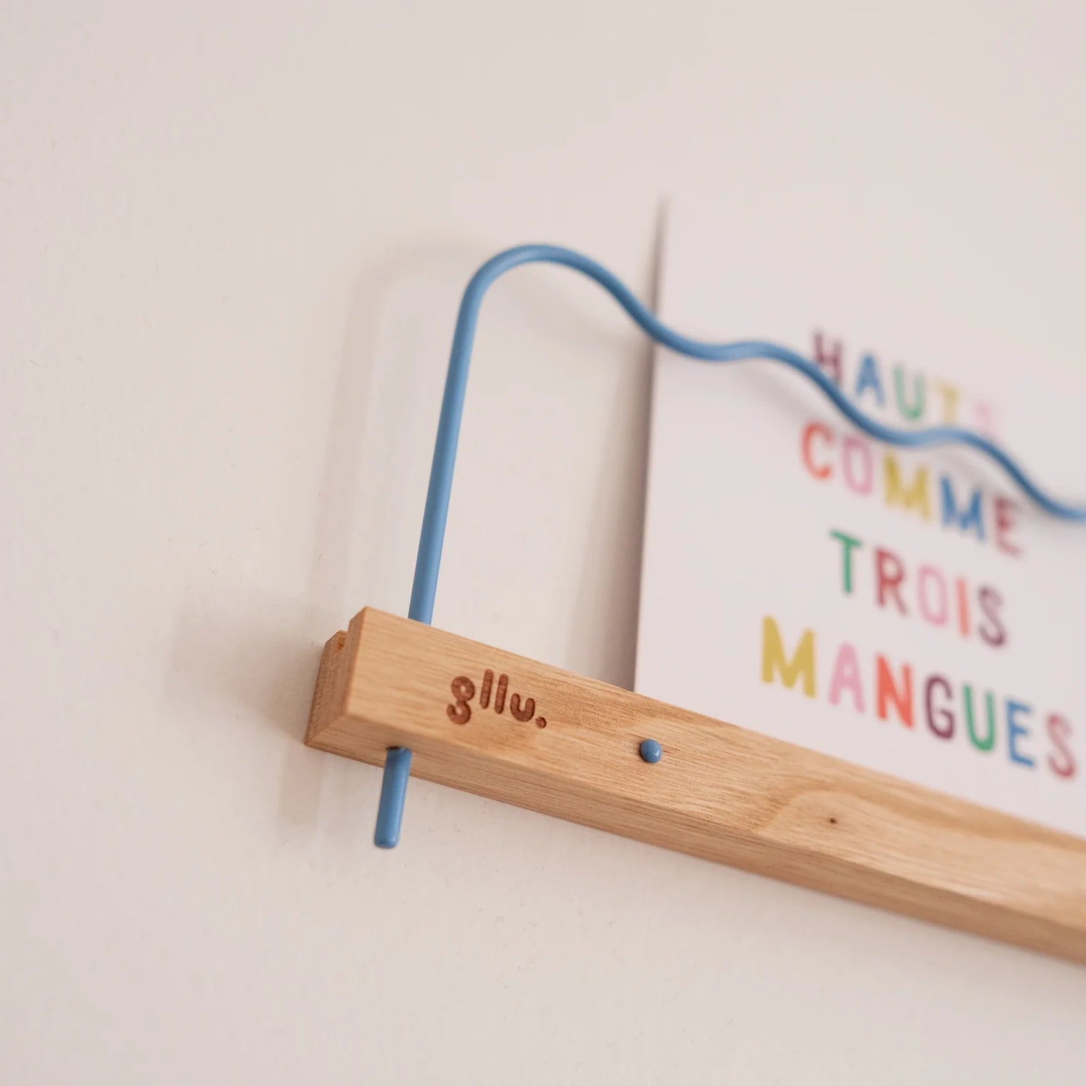 Super-Pose bilderleiste hellblau 50cm mit minimalistischer Holzleiste und bunt gestalteter Postkarte.