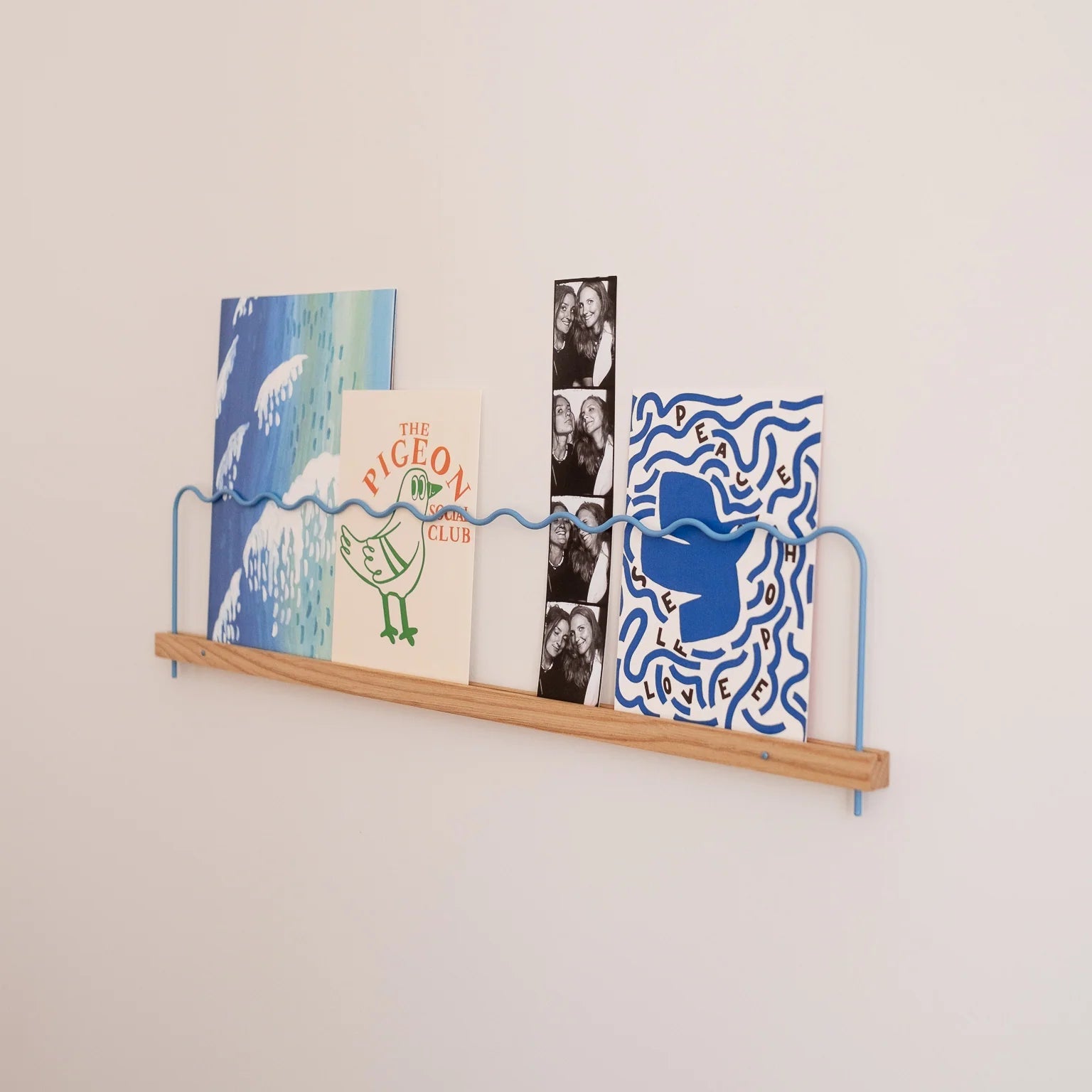 super-pose bilderleiste hellblau 50cm mit Postkarten und Notizen an der Wand